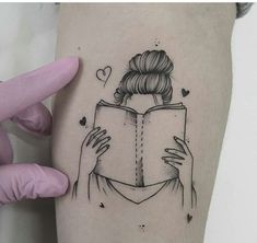 a woman's leg with a tattoo on it that has a book in her hand