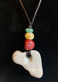 This necklace is made with an Africa-shaped hag stone collected at the Oregon coast, a red coral bead, a yellow glass bead and green aventurine strung on nylon silky cord. It is adjustable from 14 to 26 inches, and has a 3 1/4 inch drop. Adjustable Heart-shaped Gemstone Bead Necklace, Adjustable Heart Pendant Beaded Necklace As Gift, Heart-shaped Adjustable Necklace With Natural Stones, Heart-shaped Necklace With Natural Stones, Adjustable Heart-shaped Natural Stone Necklace, Casual Adjustable Necklace With Heart Beads, Unique Adjustable Heart Pendant Necklace, Casual Adjustable Heart Beads Necklace, Casual Handmade Heart Necklace