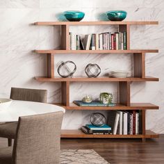 a book shelf filled with books next to a dining room table