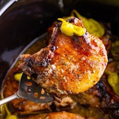 the meat is being cooked in the slow cooker with a spatula and sauce