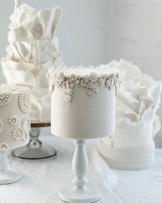 three white wedding cakes sitting on top of a table