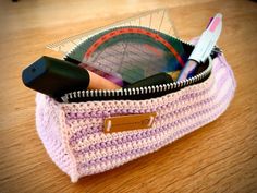 a close up of a bag on a table with pens and pencils in it