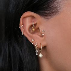 a close up of a woman's ear with three different types of piercings