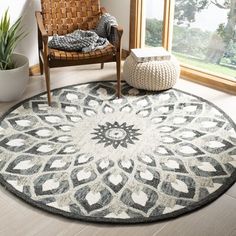 a living room area with a chair, rug and potted plant on the floor