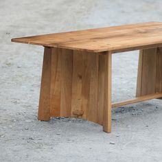 a wooden bench sitting on top of a cement ground