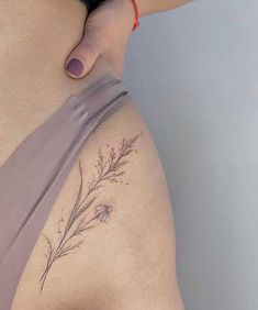 a woman's stomach with a flower tattoo on her lower back and the bottom part of her belly