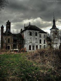 an old abandoned house with dark clouds in the background