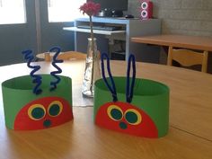 two paper hats sitting on top of a wooden table