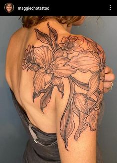 a woman with a tattoo on her shoulder and flowers in the middle of her arm