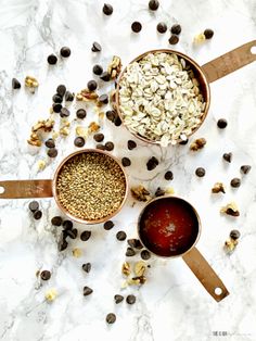 three bowls filled with oats and raisins on top of a marble counter