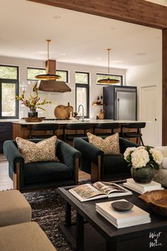 a living room filled with furniture next to a kitchen