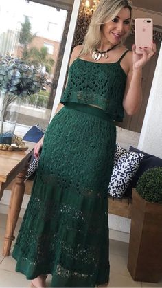 a woman in a green dress taking a selfie