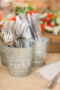 forks and spoons in metal cups on a table