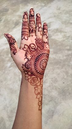 a woman's hand with henna tattoos on it