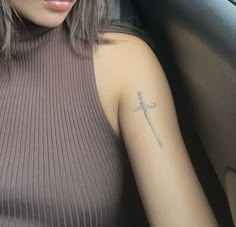 a woman with a cross tattoo on her arm