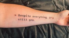 a person with a tattoo on their arm that says despite everything, it's still you