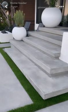 some white balls sitting on top of concrete steps in front of a house with grass