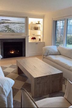 a living room filled with furniture and a fire place in the middle of a room