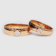 two gold wedding rings with diamonds on them