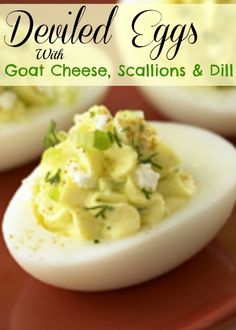 deviled eggs with goat cheese, scallions and dill on a red plate