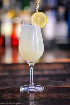 a glass filled with a drink sitting on top of a wooden table