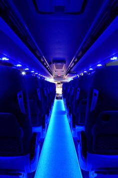 the inside of an airplane with blue lights on it's walls and flooring