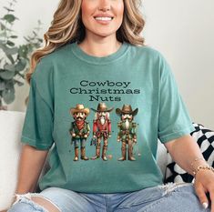 This Cowboy Christmas Nuts T-shirt is a perfect western wear Christmas attire, featuring funny and country-western designs. The relaxed fit and soft fabric make it ideal for both casual and semi-formal settings. It is relevant for those who love western wear and enjoy celebrating Christmas with a unique twist. Product features - Available in multiple sizes from S to 2XL - Double-needle stitching for durability - Garment-dyed fabric for soft color and texture - Made with 100% ring-spun US cotton Christmas Tshirts For Women Western, Christmas Nuts, Western Designs, Christmas Attire, Cowboy Christmas, Celebrating Christmas, Western Design, Nutcracker Christmas, Country Western