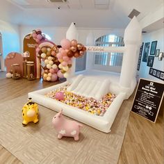 an inflatable animal and giraffe are on the floor next to some balloons