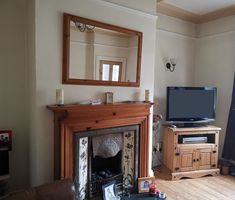 a living room filled with furniture and a flat screen tv on top of a fire place