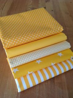 four yellow and white fabrics stacked on top of each other, with stars in the middle