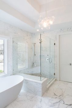 a white bathroom with marble floors and walls