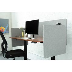 an office cubicle with two computer screens and a chair