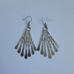 These earrings are handmade in hammered metal. They are 52 mm (2 inches) from the top of the ring to the bottom of the longest wire, and are light and comfortable to wear.  Wear with the matching fringe statement necklace for maximum effect. Modern Metal Chandelier Dangle Earrings, Adjustable Metal Dangle Chandelier Earrings, Long Drop Metal Chandelier Earrings With Ear Wire, Metal Teardrop Chandelier Earrings, Long Drop Metal Chandelier Earrings, Teardrop Metal Chandelier Earrings, Modern Metal Chandelier Earrings With Ear Wire, Modern Silver Metal Chandelier Earrings, Silver Long Drop Chandelier Earrings In Brass