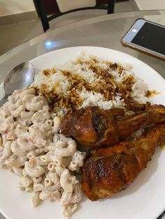 a white plate topped with chicken, rice and macaroni