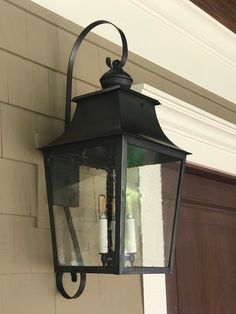 a black lantern hanging from the side of a house