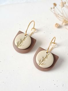 the earrings are made from clay and have gold - plated metal details on them