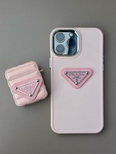 an iphone case with a pink prada logo on it next to a small wallet