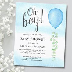 a baby shower is shown with white flowers in the foreground and a blue balloon