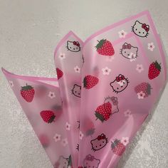 pink hello kitty paper bags with strawberrys and polka dot designs on them, sitting on a white surface