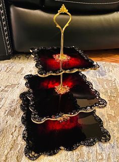 three tiered trays with red and black designs on them sitting on the floor