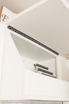 the shelves in this kitchen are filled with essential oils and other things to put on them