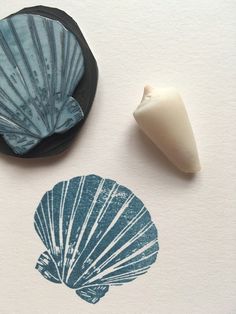 two seashells are next to a rubber stamp