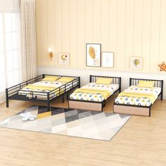 three beds in a room with wooden floors and yellow sheets on the beddings