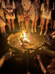 a group of people standing around a fire pit