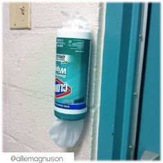 a toilet paper dispenser hanging on the wall next to a blue door