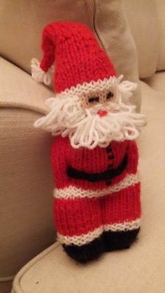 a knitted santa clause sitting on top of a couch