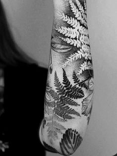 a black and white photo of a person's arm with leaves on it