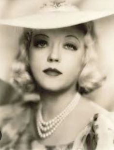 black and white photograph of a woman wearing a hat with pearls on the brim