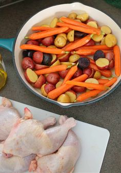 chicken, carrots, potatoes and olives in a pan on a counter top