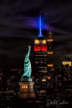 the statue of liberty lit up in red, white and blue